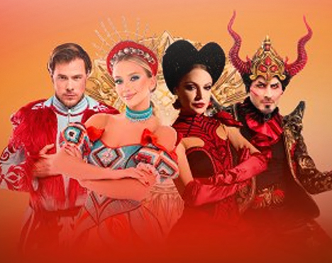 Четыре человека в ярких костюмах на оранжевом фоне. Слева направо: мужчина в красной одежде, женщина в русском наряде, женщина в черном с красным, мужчина в рогатом шлеме. Все держатся уверенно